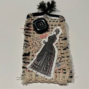 Beige decorative patch.  The patch has a pin has a pin as closure.